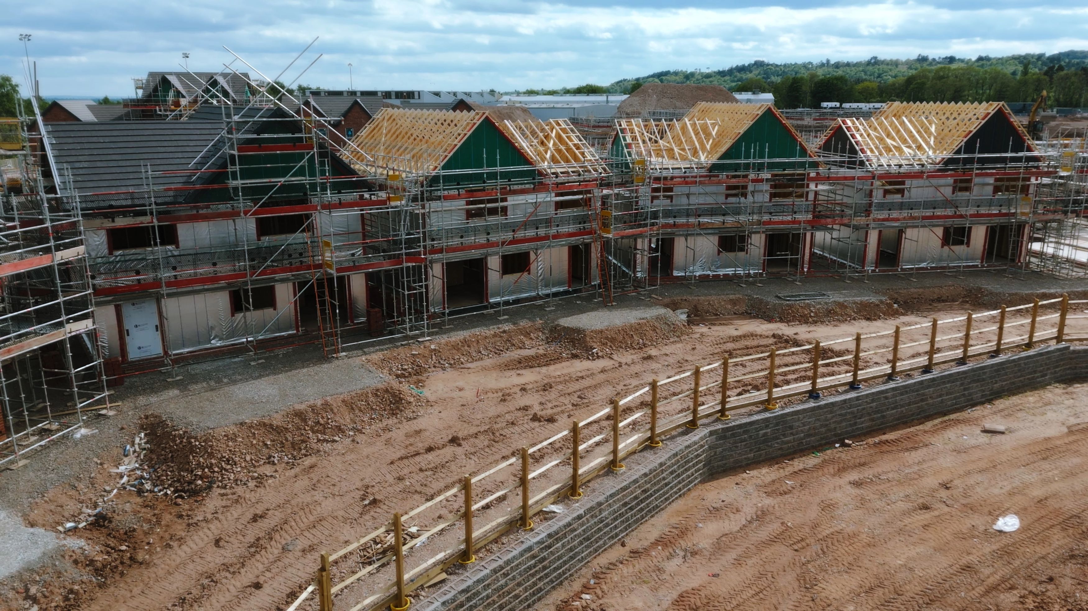 Rows of new homes under construction surrounded by Stag scaffolding and exposed timber roof frames.
